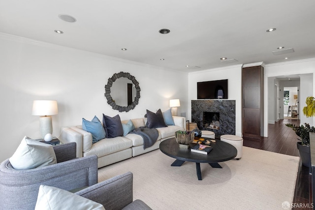 living area with ornamental molding, recessed lighting, dark wood-style flooring, and a premium fireplace