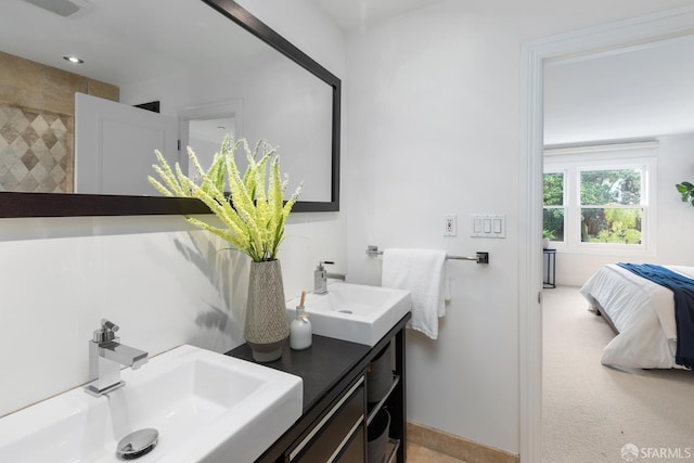 ensuite bathroom with double vanity, a sink, and ensuite bathroom