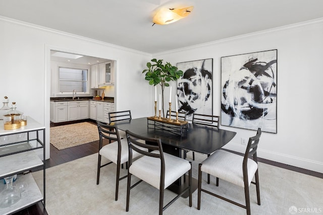 dining area featuring ornamental molding, wood finished floors, and baseboards