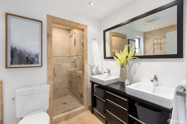 bathroom featuring toilet, a shower stall, and a sink