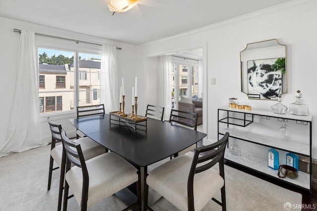 dining space with baseboards and crown molding