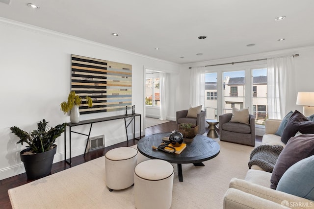 living room featuring ornamental molding and wood finished floors