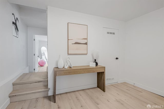 interior space featuring visible vents, light wood-type flooring, and baseboards