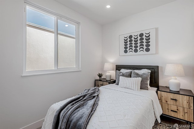 bedroom with recessed lighting, multiple windows, baseboards, and wood finished floors