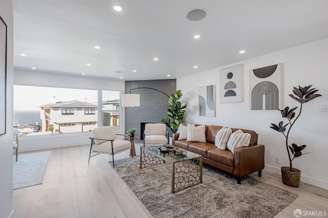 living area featuring recessed lighting, a fireplace, baseboards, and wood finished floors