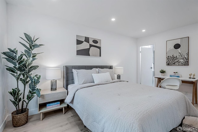 bedroom with light wood finished floors and recessed lighting