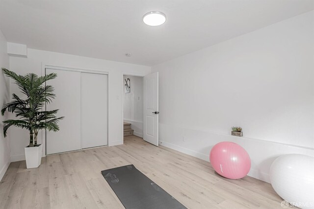 exercise room with baseboards and wood finished floors