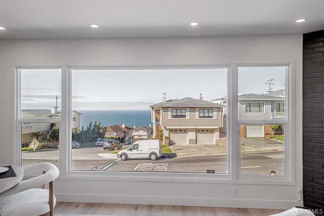 interior space featuring recessed lighting, baseboards, a water view, and wood finished floors