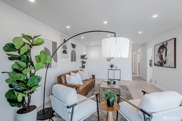 living area featuring recessed lighting, baseboards, and light wood finished floors