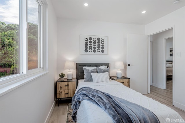 bedroom featuring recessed lighting, baseboards, and light wood-type flooring