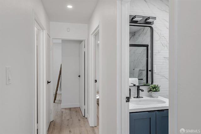 hallway with a sink and light wood-style flooring