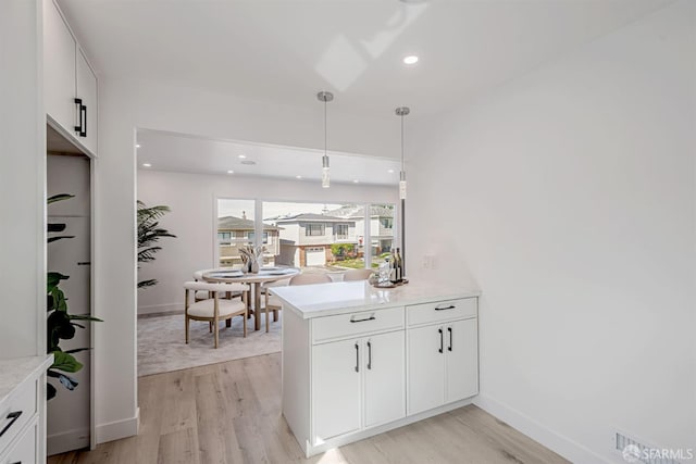 kitchen featuring white cabinetry, light wood-style floors, a peninsula, and light countertops