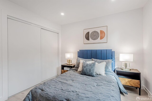 bedroom featuring recessed lighting, wood finished floors, and a closet