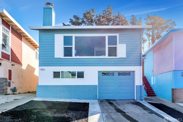 view of front of home featuring stairway, concrete driveway, and stucco siding