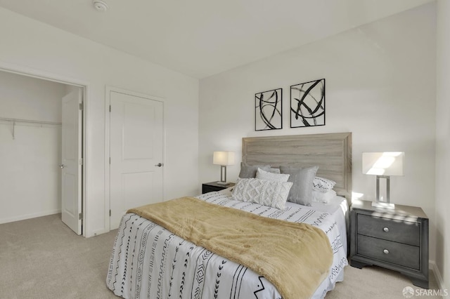 bedroom with light carpet, a walk in closet, and a closet