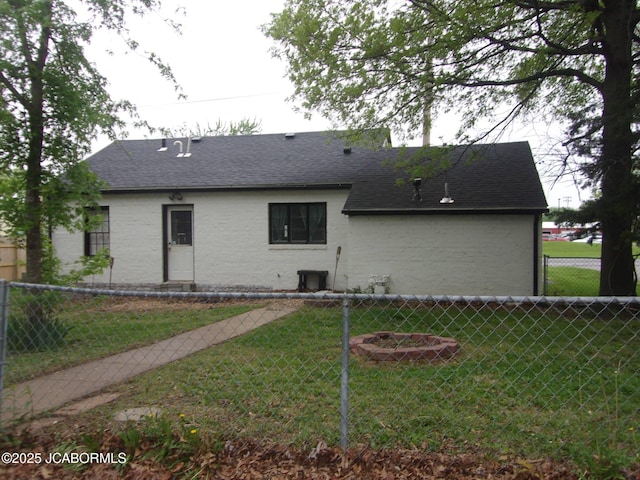 1300 S Morris St, Mexico, MO 65265 - back of house featuring fence, a shingled roof, and a lawn