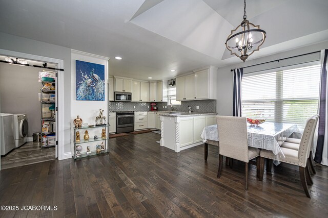 dining area featuring washer and dryer, an inviting chandelier, dark wood-style flooring, and recessed lighting