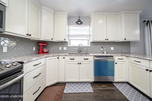 kitchen with dark wood-type flooring, tasteful backsplash, appliances with stainless steel finishes, and a sink