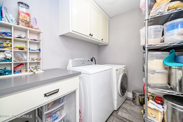 washroom with washing machine and dryer, marble finish floor, and cabinet space