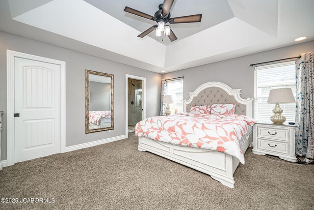 bedroom featuring baseboards, carpet, a raised ceiling, and multiple windows