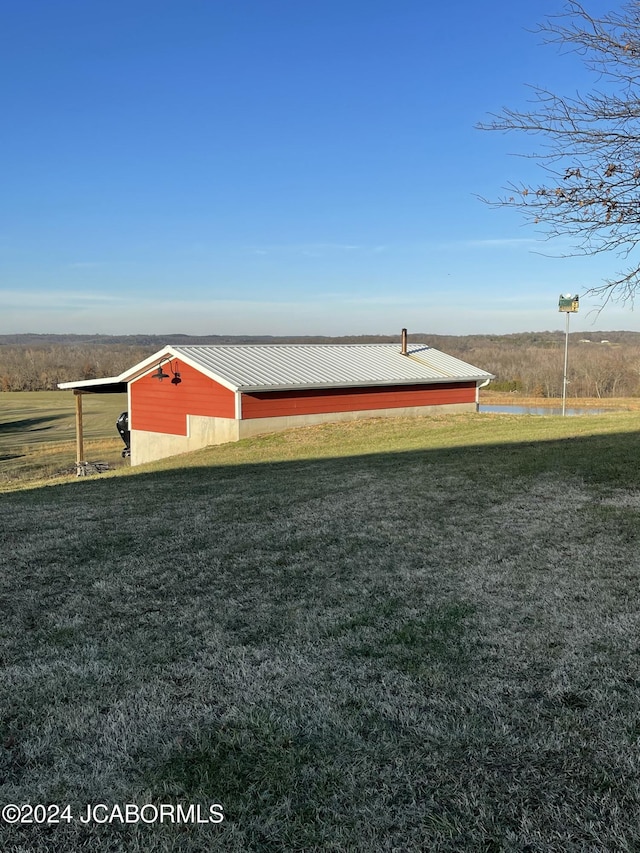 surrounding community featuring a lawn, a rural view, and an outbuilding