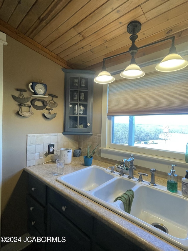 kitchen with wooden ceiling, sink, ornamental molding, tasteful backsplash, and decorative light fixtures