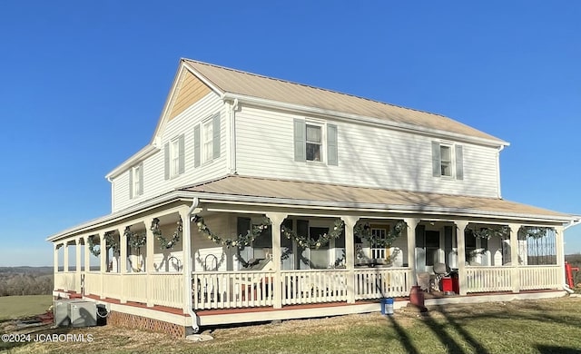 farmhouse featuring a porch and a front lawn