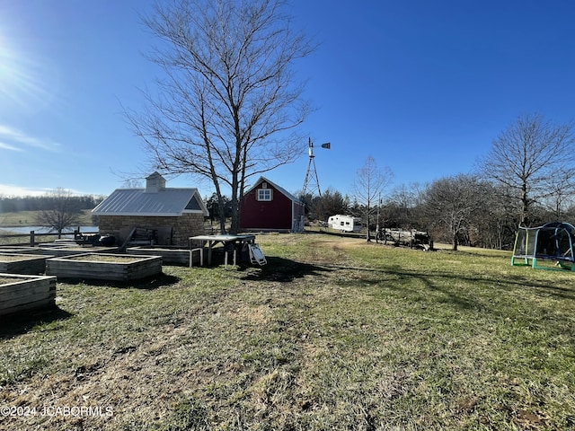 view of yard featuring an outbuilding and a trampoline