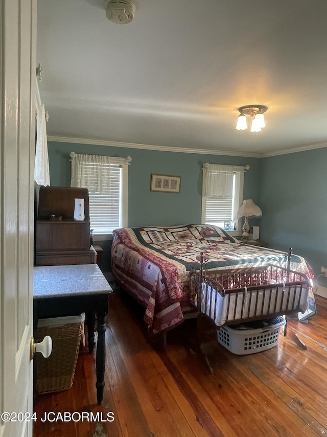 bedroom featuring dark wood-type flooring and crown molding