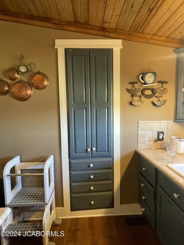 bathroom featuring vanity, wood-type flooring, wood ceiling, and backsplash