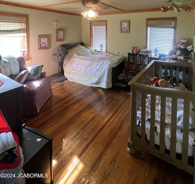 bedroom with ceiling fan, wood-type flooring, and ornamental molding