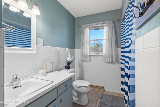 bathroom featuring toilet, curtained shower, tile walls, tile patterned flooring, and vanity