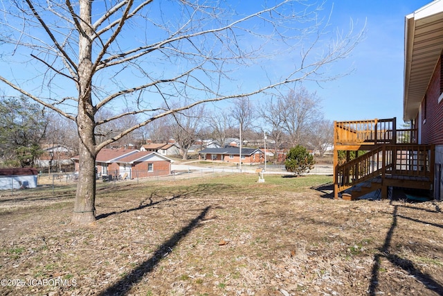 view of yard featuring stairs, fence, a residential view, and a wooden deck