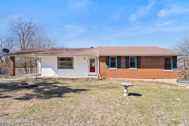 ranch-style house with brick siding, an attached carport, roof with shingles, and a front yard