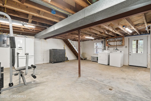 below grade area with washer and clothes dryer, stairway, and electric panel