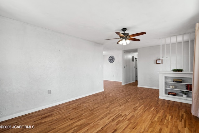 unfurnished living room with baseboards, wood finished floors, and a ceiling fan