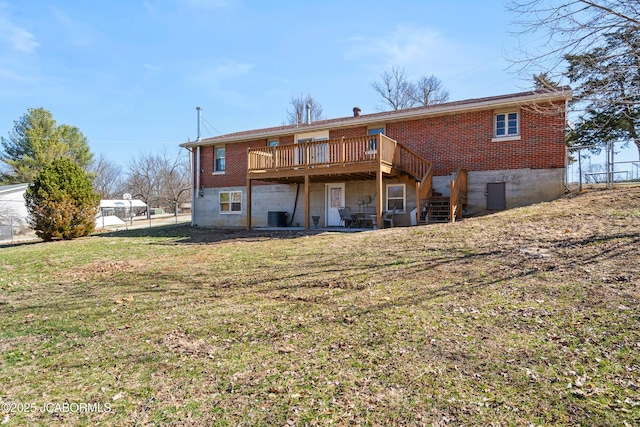 rear view of property with a deck, fence, a yard, brick siding, and central AC unit