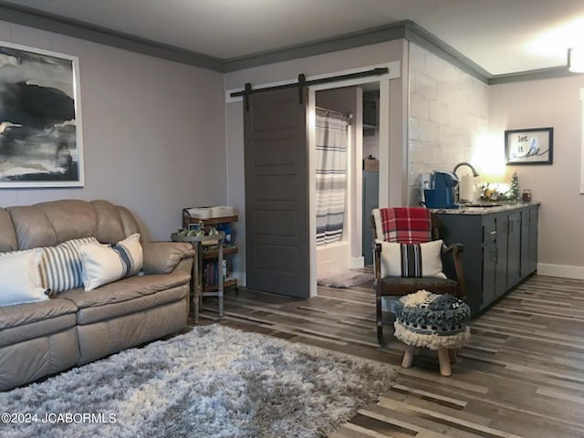 living room featuring hardwood / wood-style floors, a barn door, sink, and crown molding