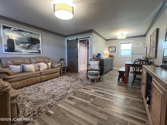 living room featuring hardwood / wood-style floors, a barn door, and ornamental molding