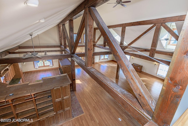 interior space with ceiling fan, plenty of natural light, wood-type flooring, and vaulted ceiling