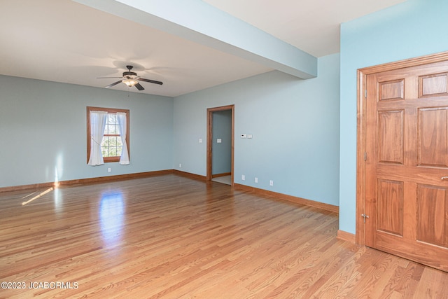 unfurnished room featuring beamed ceiling, light wood-type flooring, and ceiling fan