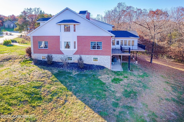 rear view of property with a deck and a yard