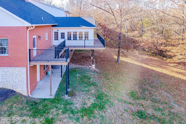 exterior space featuring a wooden deck and a patio area