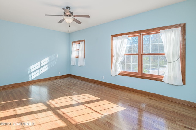 empty room with ceiling fan and hardwood / wood-style floors