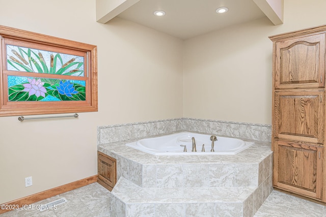 bathroom featuring tiled bath and tile patterned flooring