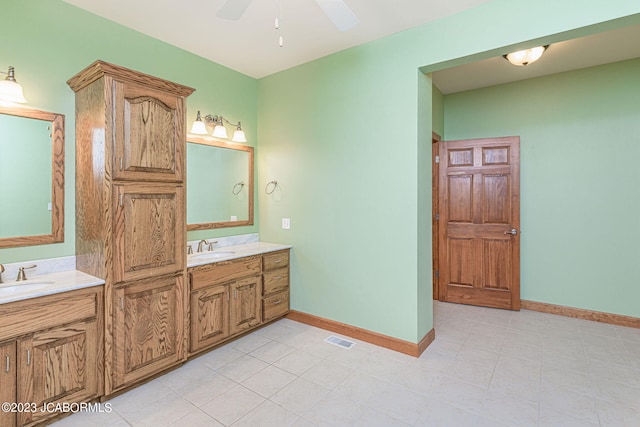 bathroom with tile patterned flooring, vanity, and ceiling fan