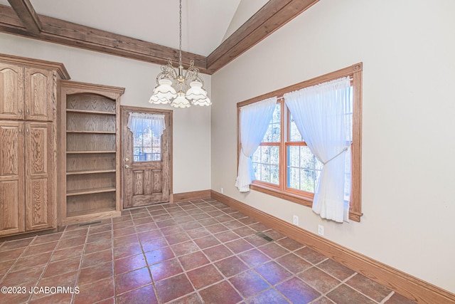 unfurnished dining area with dark tile patterned flooring, vaulted ceiling, and an inviting chandelier