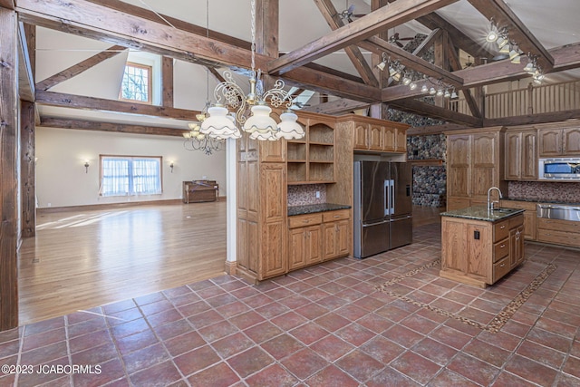 kitchen with tasteful backsplash, a kitchen island with sink, high vaulted ceiling, and appliances with stainless steel finishes