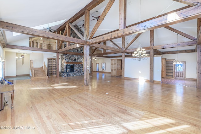 unfurnished living room with ceiling fan, light hardwood / wood-style floors, beam ceiling, and high vaulted ceiling