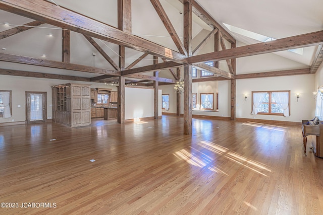 unfurnished living room featuring hardwood / wood-style flooring and high vaulted ceiling